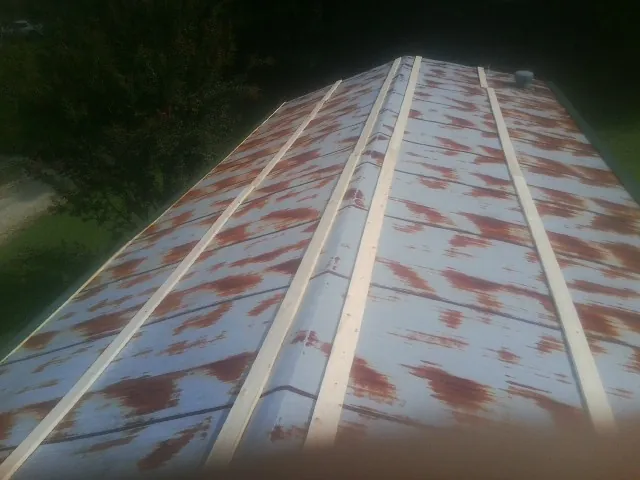 Rusted metal roof panels with new wood purlins before replacement — Storm Damage Roof Repair in Bartlett by Roofing Brothers